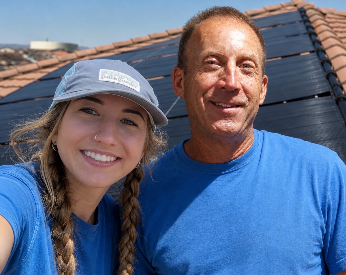 Paige Pierce and Bill Pierce of Solar Pool Services on a tile roof in front of a solar pool heating system