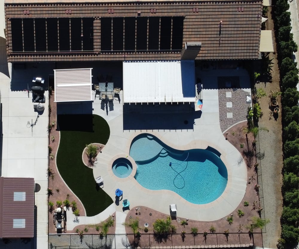Aerial view of a home's solar collectors, pool, and equipment