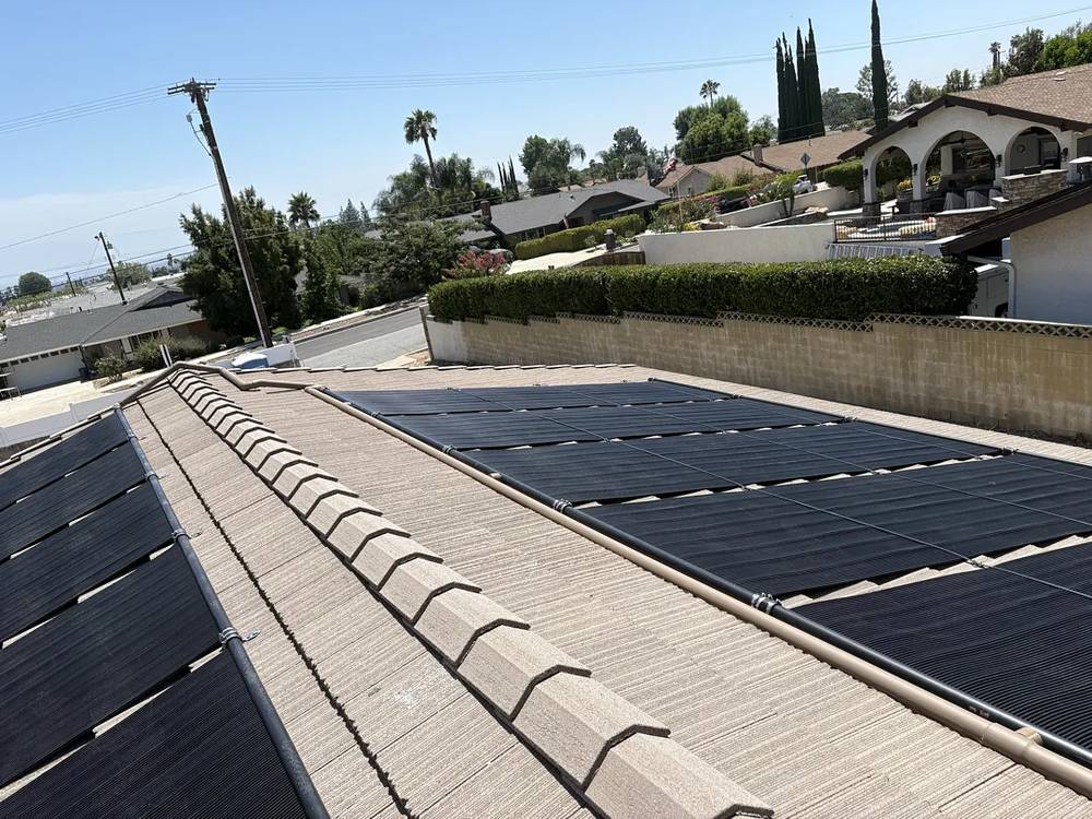 Solar pool heating panels on both slopes of a tile roof in Rancho Cucamonga